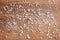 Large crystals of sea salt on a brown wooden cutting board. Cooking background, top view