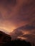 Large cumulonimbus cloud blocking a flowing cirrus clouds on a sunset