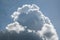 A large cumulus cloud in a blue sky with cirrus clouds.