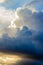 Large cumulus, nimbus clouds with silver lining, in blue, gold and white