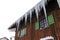 Large dangerous icicles and a roof avalanche on a house roof in winter