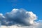 A large dark Cumulus cloud obscures the clear blue sky.