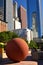 A large decorative cement ball stands still in Pershing Square