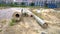 Large diameter concrete pipes lie on the ground. Pile of sand and rubbish. Building. Civil engineering. Pipeline repair.