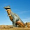 A large dinosaur statue in Drumheller, Alberta, Canada against a vivid blue sky.