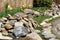 Large dirty stones in the background of the pool. Construction and cleaning of an ornamental pond in the garden. landscape design