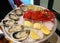 Large dish with fresh seafood, oysters with lobster with lemon and sauce on ice