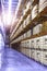 Large distribution warehouse interior, pallets and boxes of cargo stack on row of high shelves.