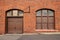 A large door and window on the side of a red bricked building