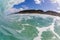 Large dramatic wave breaking hard over volcanic reef in hawaii