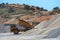 Large dump truck with the tipper raised unloading sand