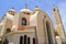 large Egyptian orthodox white church with crosses, arches, domes and windows for prayers.