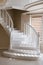 Large elegant stairs and white railings made of natural wood