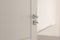 Large elements of the interior of the apartment. White door. Chromed door handle and lock with key. selective focus