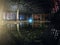 Large empty abandoned warehouse building or factory workshop at night with reflection in water, abstract ruins background