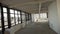 Large empty hall with big black framed windows and white walls and ceiling.