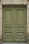 Large entrance double-leaf green door to a stone house