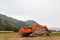 Large excavator with a lowered bucket during repair work in the mountains on a summer day