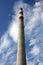 Large factory concrete chimney. Steam escapes from the pipe against the sky. Industrial emissions of pollutants into the
