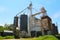 Large farming community co-op agricultural feed grain and corn silo and elevator building against a blue sky in rural america