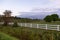 Large fenced country property with rows of cultivated fruit trees headed by wooden signs