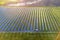 Large field of solar photo voltaic panels system producing renewable clean energy on green grass background