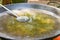 Large flat frying pan or skillet for paella or jambalaya on gas burner. Process of heating olive oil for cooking meat vegetables