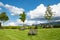 Large fluffy white clouds over meadow with deck chairs in landscape of Allgau, German Alps,