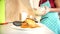 A large foot of pancakes in the plate in the foreground. In the background, a girl chef pours pancake mixture into a