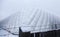 Large football tent behind barbed wire on which it snowed