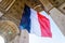 A large french flag fluttering under the Arc de Triomphe in Paris, France