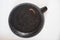 A large frying pan without a handle, with a burnt bottom on a white background. Close-up