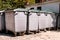 Large garbage containers, trash dumpsters and bins standing in row. Orderly stowed garbage cans ready for separate garbage.