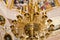 Large gilded chandelier in the temple of God on the background of icons and murals