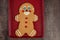 Large gingerbread cookie on a red cookie sheet on a wood table