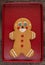 Large gingerbread cookie on a red cookie sheet on a wood table