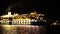 Large glowing lights cruise liner floats on the sea at night