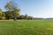 Large grassplot with mown grass against autumn forest