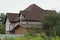 Large gray private house with a brown tiled roof