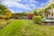 Large green fenced backyards with fall landscape and view of the deck.