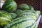 Large green striped watermelons. Fruit background on the counter in the market. Common watermelon Citrullus lanatus