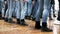 Large group of children synchronously dance in blue jeans and black boots. training