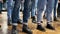 Large group of children synchronously dance in blue jeans and black boots. training