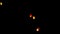 A large group of Chinese flying lanterns fly into the dark night sky.
