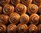 a large group of cinnamon buns on a black background