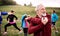 Large group of fit and active people doing exercise in nature, stretching.