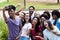 Large group of multi ethnic young adults taking crazy selfie with phone