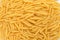 Large group of penne Italian pasta ready to be cooked, displayed as background with top view