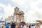 a large group of people gathered outside a church together holding up palm trees