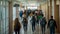 A large group of people, including students, walking down a bustling hallway, A bustling hallway filled with students of different